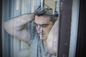 Man in despair at window asking how much does drug detox cost